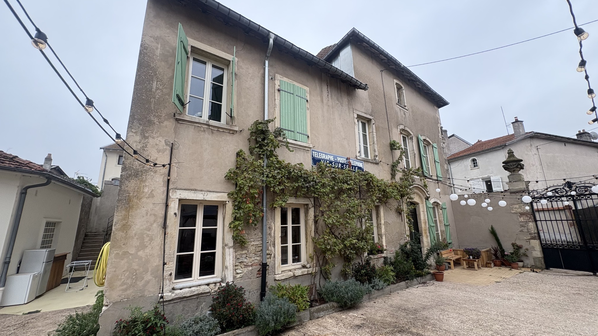 Façade côté cour avec végétation et panneau Télégraphe Poste Téléphone Vic-sur-Seille