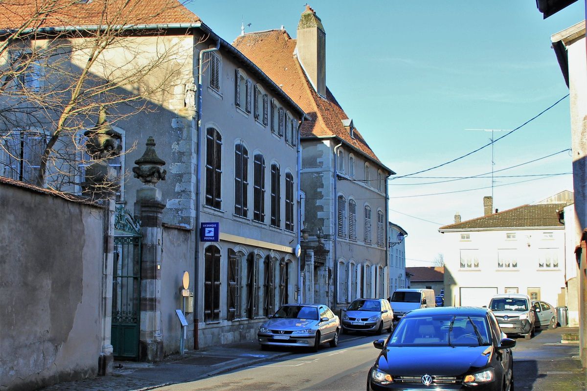 Façade de l’ancienne poste avec des enseignes La Banque Postale et des voitures dans la rue