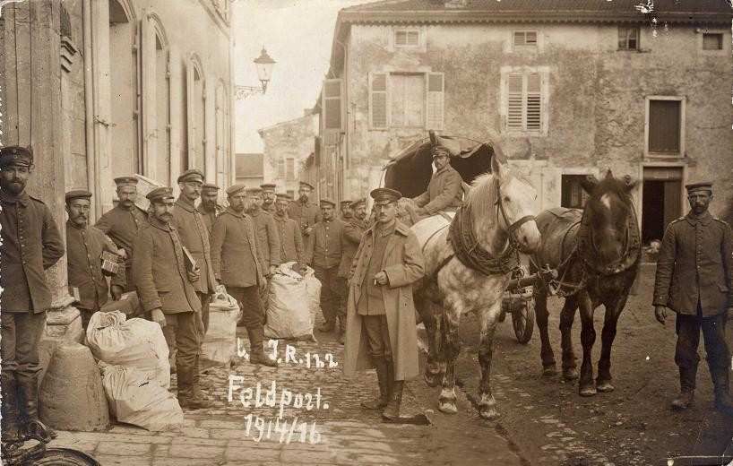 Militaires et sacs devant une façade avec un attelage et une inscription Feldpost